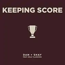 Promotional cover art of "Keeping Score", displaying a trophy icon at the center. Above it, the title of track is printed in a large typeface; below, the artists Dan + Shay feat. Kelly Clarkson are printed in a small typeface.