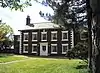 A symmetrical Georgian style, brick-built farmhouse in five bays with a short wing on each side.