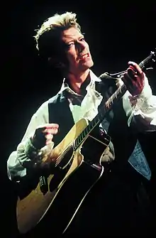 A man standing while playing a guitar