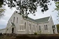 This cruciform church with its neo-Gothic characteristics, was designed by the architect George Wallis of Oudtshoorn.
The corner-stone was laid on 28 November 1900 by the Rev. J. A. Beyers and the building was officially inaugurated on 28 November 1902.
The impressive pulpit designed by another local architect, J. E. Vixseboxse, and installed in 1911, is also noteworthy.
The old hall, which was erected in 1904, was used as school from 1904 to 1913. At present it serves as church hall.
Type of site: Church and Parsonage