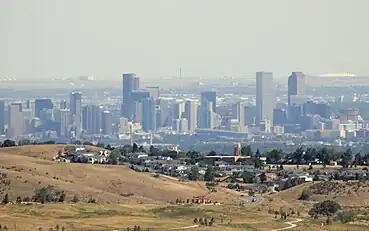 Downtown Denver view from Red Rocks Amphitheatre in 2011, with the control tower for Denver International Airport and the peaks of its Jeppesen Terminal building in the distant background