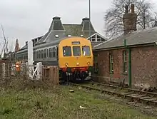 Class 101 DMU crossing Neatherd Road north of Dereham station