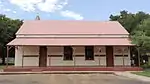 Type of site: School. This plain little building was completed early in 1898 as the first permanent school building at Kroondal. Together with the nearby Old Lutheran Church it forms the historical core of the town of Kroondal.