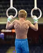 Contraction of the latissimus dorsi muscle of another artistic gymnast on still rings.