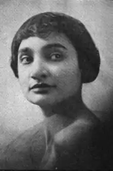 A young woman with olive skin and short dark hair cut into a bob with bangs