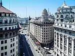 View of a street, flanked by high buildings, from above