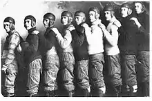 members of a football team wearing old-fashioned leather helmets