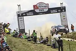 The Ford Fiesta WRC of Elfyn Evans and Daniel Barritt jumping at the Rally de Portugal's iconic Fafe stage.