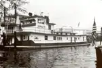 Black-and-white photo of long towboat on the water