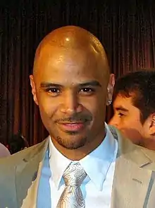 A man wearing a suite with a beige tie.