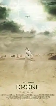 In a desert landscape, a Middle Eastern boy points a slingshot at an unmanned aerial vehicle flying above the clouds.