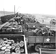 Drums of  oil being transferred from rail cars to lorries, WWII