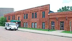 Two-story brick building with United States Postal Service vehicle in front of it