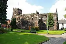 A Gothic church with a transept, clerestory, and west tower, all battlemented