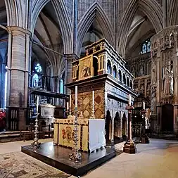 A large, elaborately-decorated tomb with an altar in front.