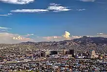 Buildings and mountains in a large city during the afternoon