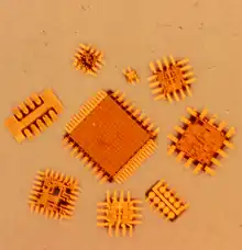 Silicon integrated circuits showing attached and extended electroformed beam leads around the silicon chip