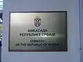 Plaque outside the embassy in English and Serbian depicting the Coat of arms of Serbia, lesser version