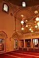 The prayer hall of the mosque, with the women's upper gallery, and a view of Islamic frescos along the arches and squinches