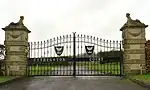 black metal gates between stone gate piers