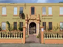 Photograph of the Padre Nazario School, a two story, flat roofed structure