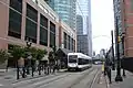 Looking east along Essex Street at westbound trolley with Liberty View Towers in background on a cloudy morning.