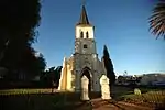 Narrow church with buttressed steeple with octagonal spire. Louvred vents with pointed arches to steeple. door with pointed arch. Type of site: Church Current use: Church : Lutheran.