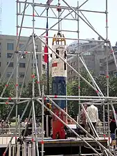 color image of the Phoenix 2 capsule held upright by scaffolds in a central square on display in Santiago, Chile