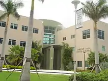 Picture of a 3-story tan building which hosts one of Florida Atlantic University's academic colleges