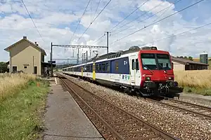 White train on tracks next to platform