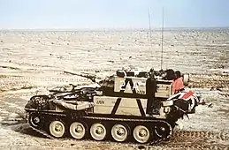 small armoured vehicle alone in the desert. The flag of the United Kingdom can just be seen on the rear