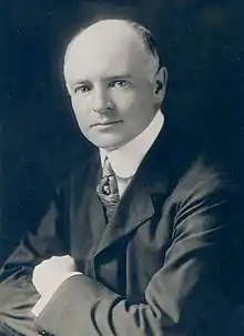 Sepia photograph of a middle-aged man in a dark suit and white shirt