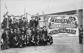 Members of the Bendigo Branch of Ironmoulders Union, standing next to a union banner at a celebration or procession