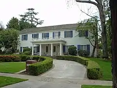 A white house with blue shutters is pictured