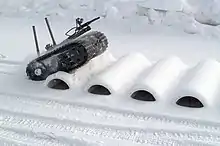 A robotic vehicle undergoes mobility testing on a bump course at CRTC.