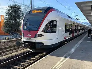 White train on tracks next to platform