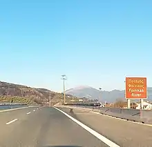 Road sign with the inscription "Foinikas River" (On the Olympia Odos highway bridge over the river)