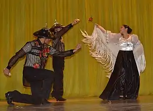 Dancers from the Philippines performing Jota Manileña. The woman is wearing a mantón de Manila over her traditional traje de mestiza dress