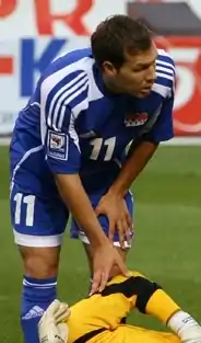 A dark-haired white man wearing blue-and-white sports clothing