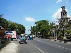 Agoo town center along the National Highway with the steeple of Basilica Minore of Our Lady of Charity on the right