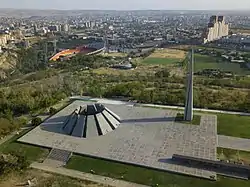 Spiky monument perched on a hill above a large city