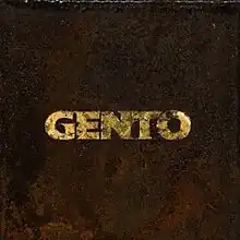 The cover art for "Gento": The song's title, "Gento", is written in gold material on top of a rusty brown background.