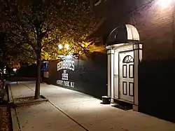 Dark wall with white text and white door at night