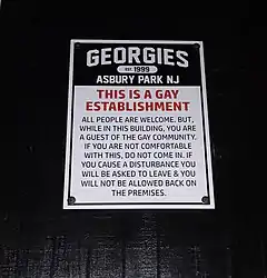 Sign bearing the following text: "This is a gay establishment. All people are welcome. But, while in this building, you are a guest of the gay community. If you are not comfortable with this, do not come in. If you cause a disturbance you will be asked to leave & you will not be allowed back on the premises.