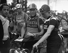 Three male cyclists standing in a row