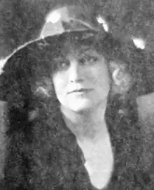 A young blond woman wearing a hat with a wide brim