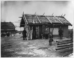 Goldi village along the Amur River, north of Khabarovsk 1895.  Note the dried sturgeon leaning against the home and atop its thatched roof.