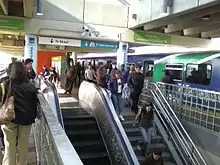 A busy metro station during rush hour with many passengers leaving the train and exiting the station.