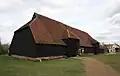 Grange barn, Coggeshall, England. This is a studded barn so the wall sheathing must be applied horizontally and covered with a siding material, in this case clapboards (weatherboards).