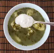 Green borscht with spinach and potatoes, topped with smetana